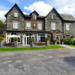 The Coniston Inn in Coniston Cumbria. a beautiful traditional style building with lakeland stone. Car parked to the right