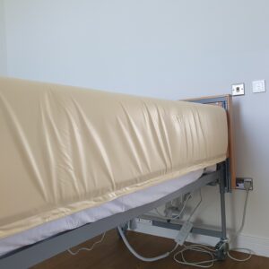 Cream waterproof bumper on side rail of profiling bed